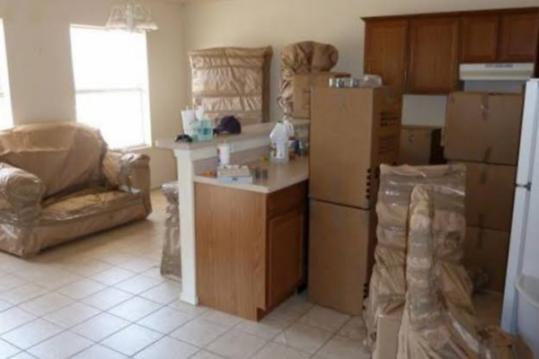 Professional movers loading furniture into a truck outside a modern home